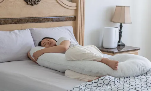 Беременная спит с подушкой между ног