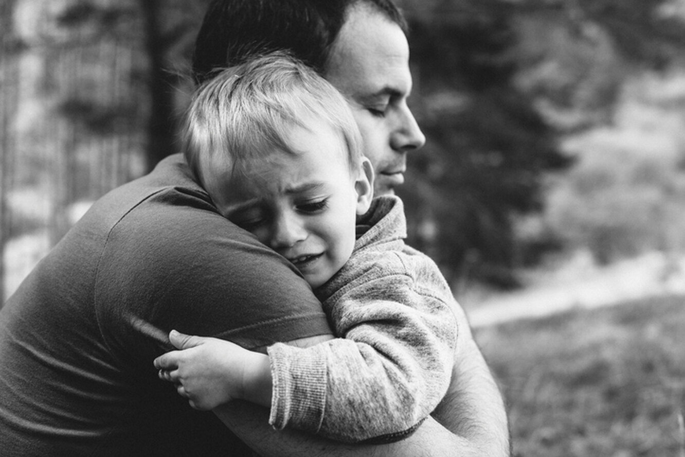 Отец обнимает сына